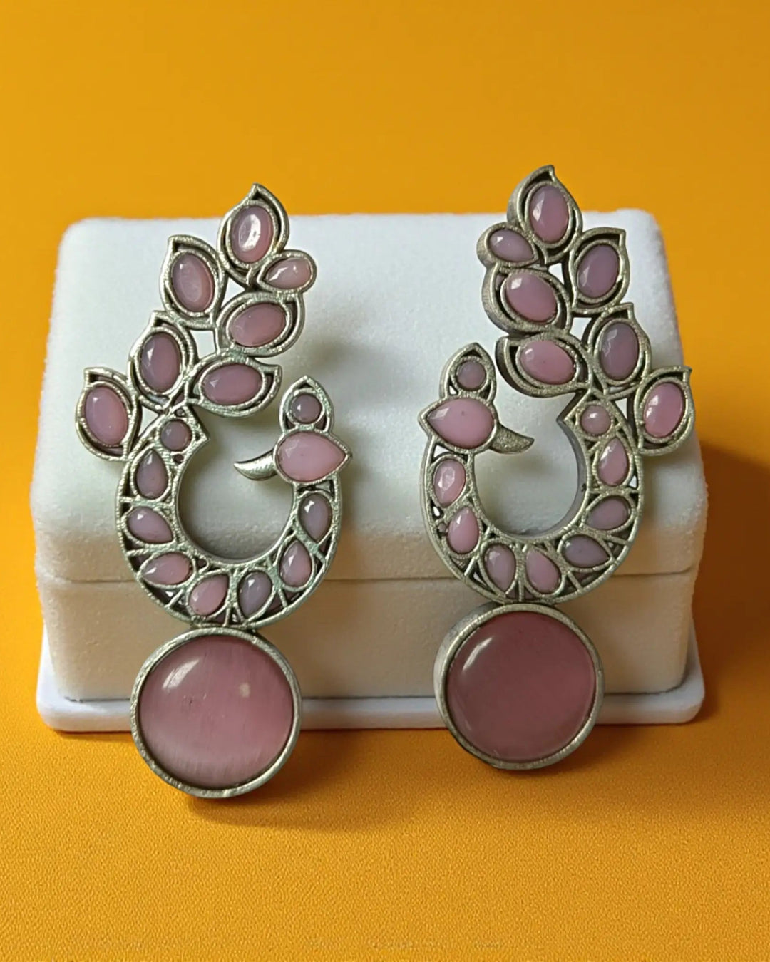 Pink tones brighten the oxidised surface of this earring.