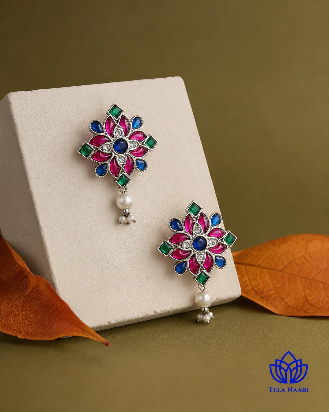 Delicate floral silhouette pairs brass with lustrous pearl accents.