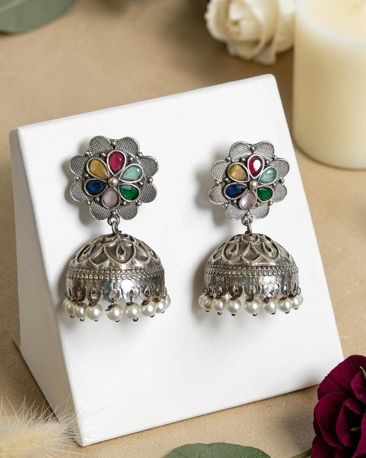 Darkened oxidised finish gives this bell-shaped jhumka its antique look.