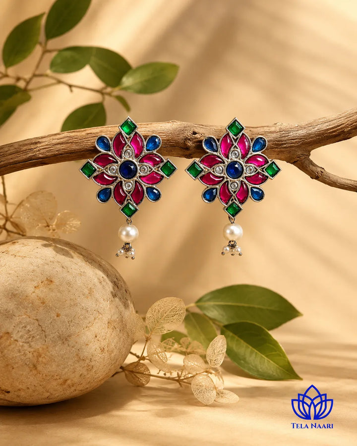 Textured brass surface supports the floral pearl earring design.
