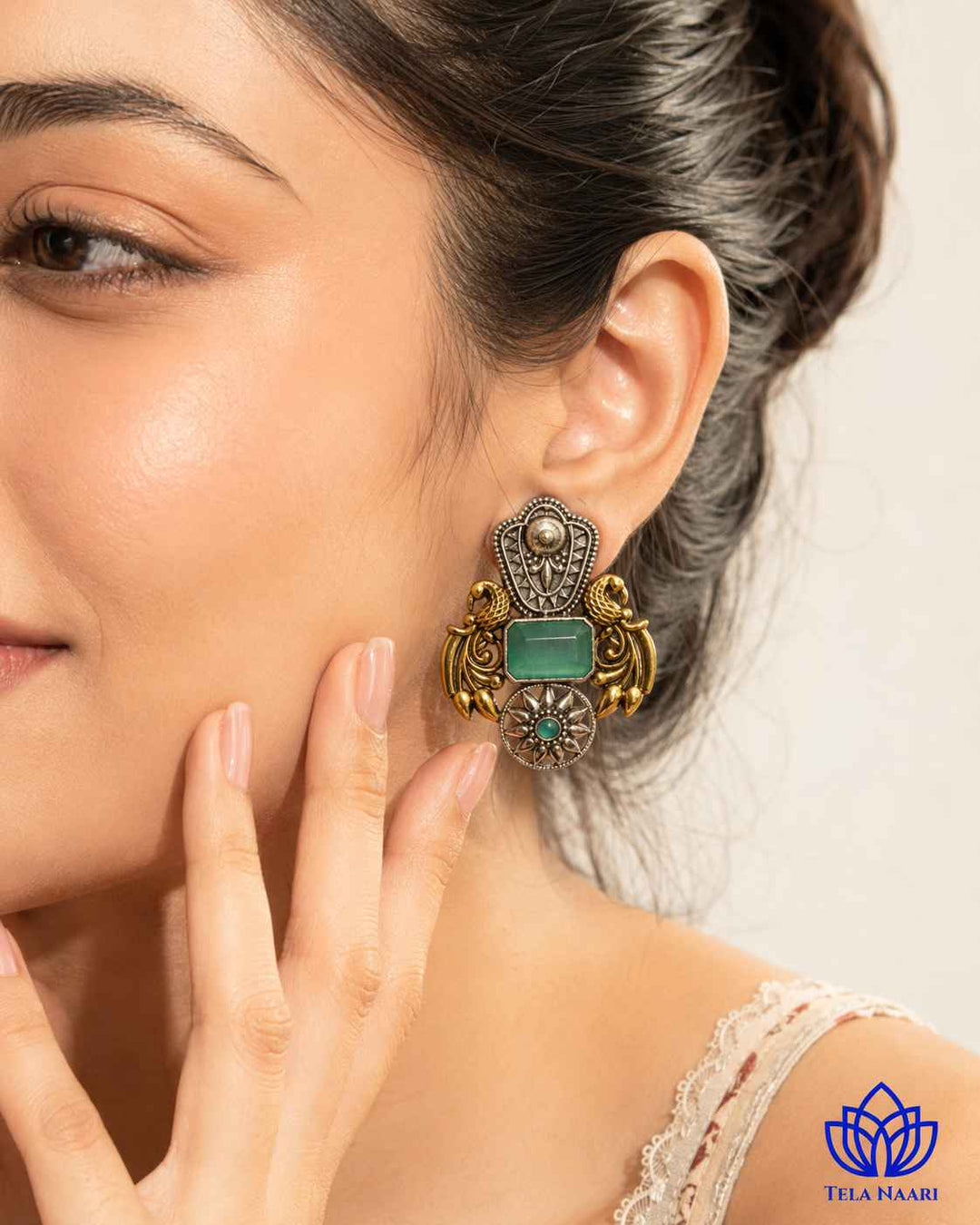 Statement silhouette combines sea green with dual-tone plating.