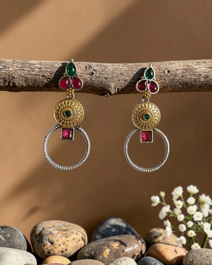 Ruby red and green stones sit at the centre of this earring.