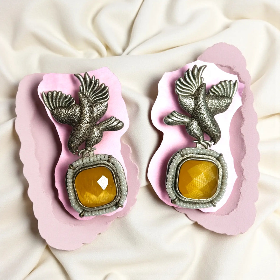 Artificial stone accents highlight the centre of this bird earring.