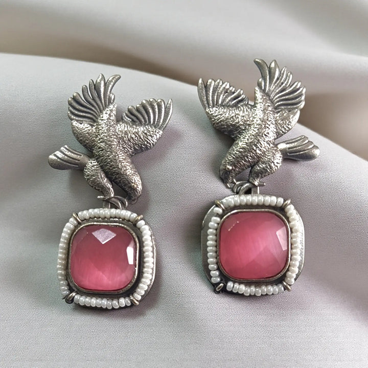 Intricate bead work outlines the bird silhouette of this earring.