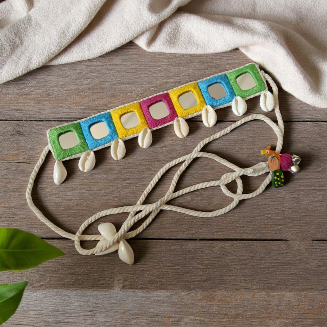 Cowrie shells decorate the surface of this pastel fabric choker.