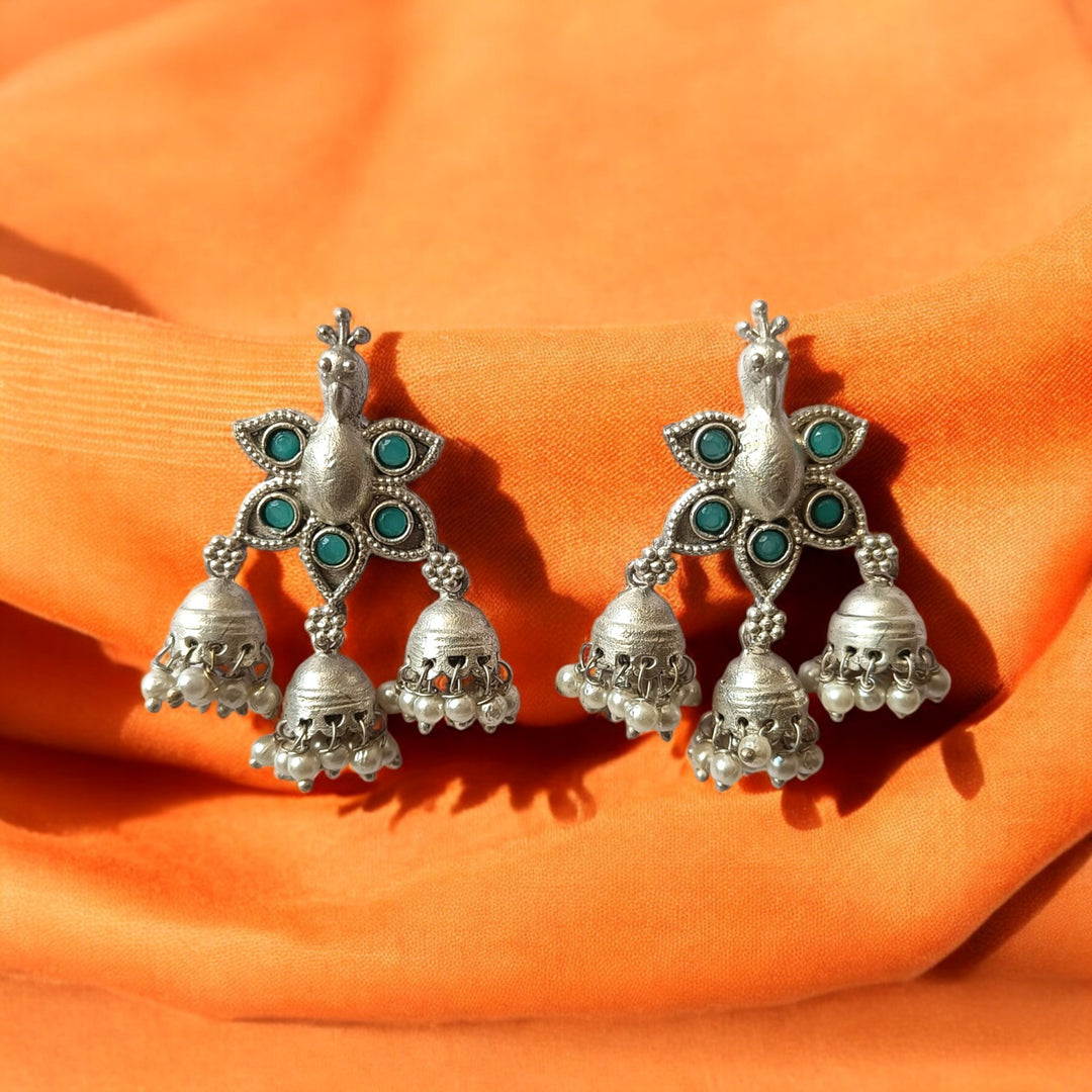 Brass construction supports the silver-plated peacock design.