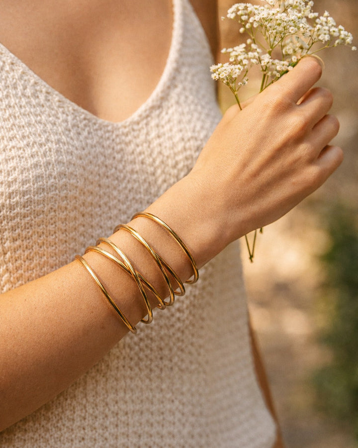 Polished surface highlights the sculpted shape of this brass cuff.
