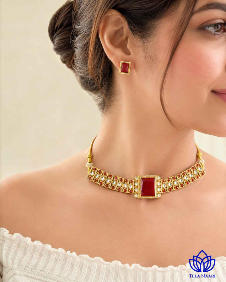 Matching earrings complete this red gold-plated choker set.