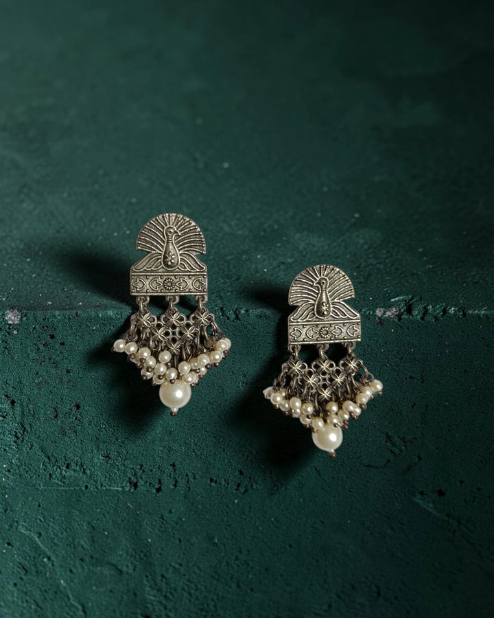 Brass construction supports the intricate peacock craftsmanship of this earring.