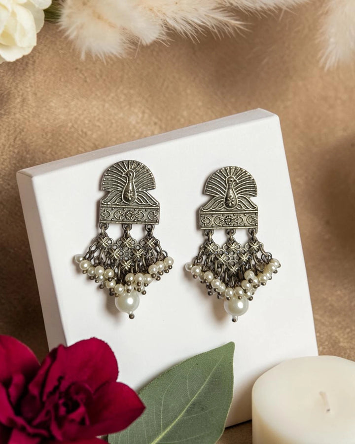 Majestic peacock detailing shapes the silhouette of this earring.