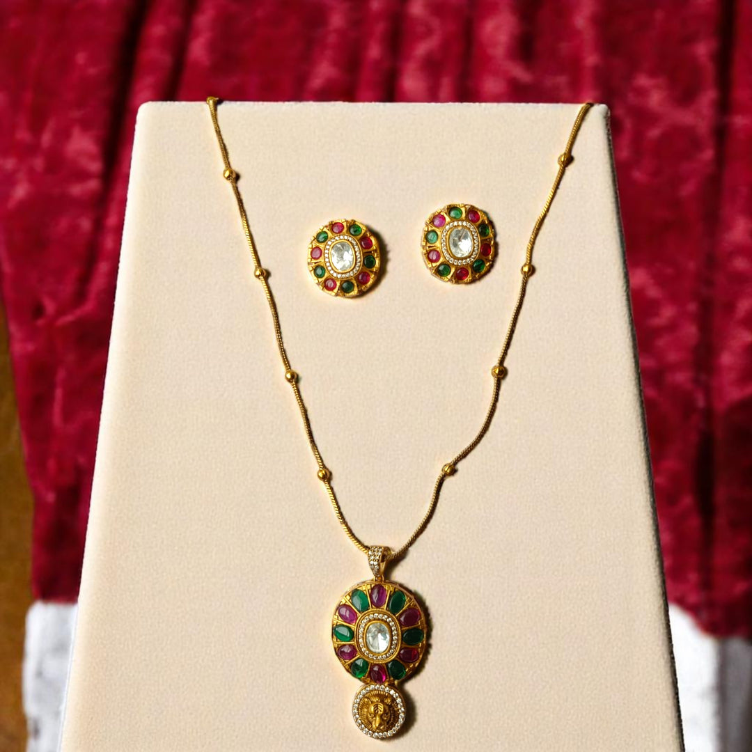 Ruby red and emerald green stones decorate the surface of this pendant.