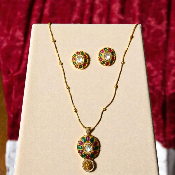 Ruby red and emerald green stones decorate the surface of this pendant.