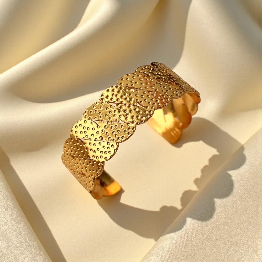 Delicate scallop texturing catches the light across this gold cuff.