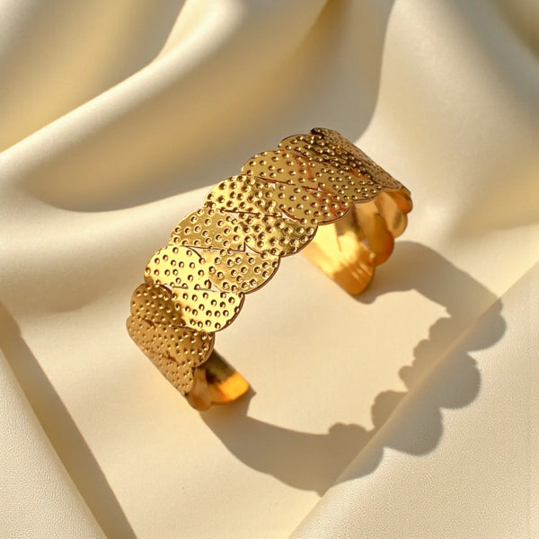 Delicate scallop texturing catches the light across this gold cuff.