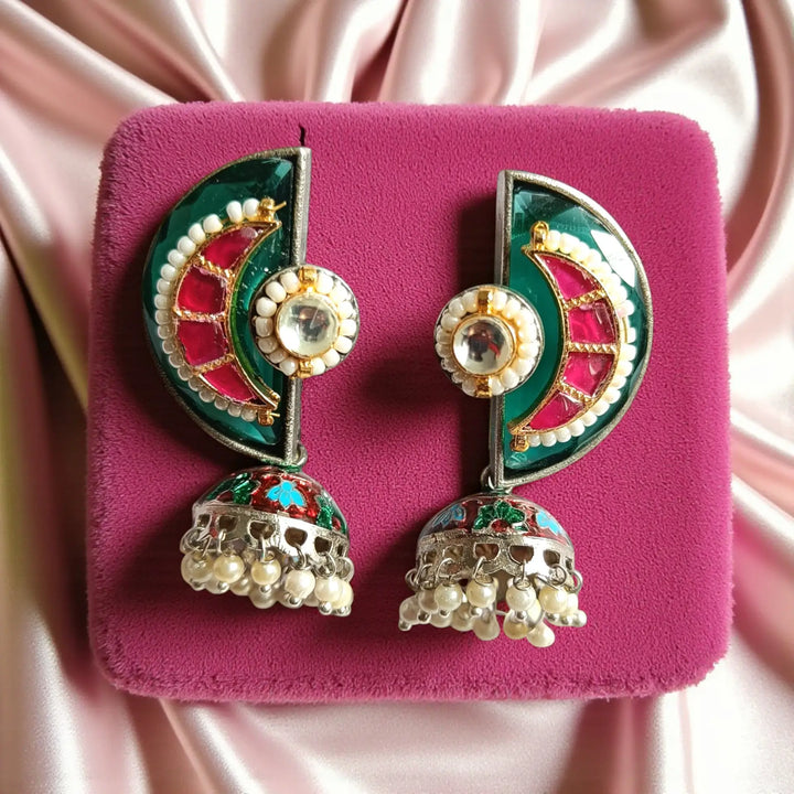 Green tones brighten the dual-tone silver-plated surface of this earring.