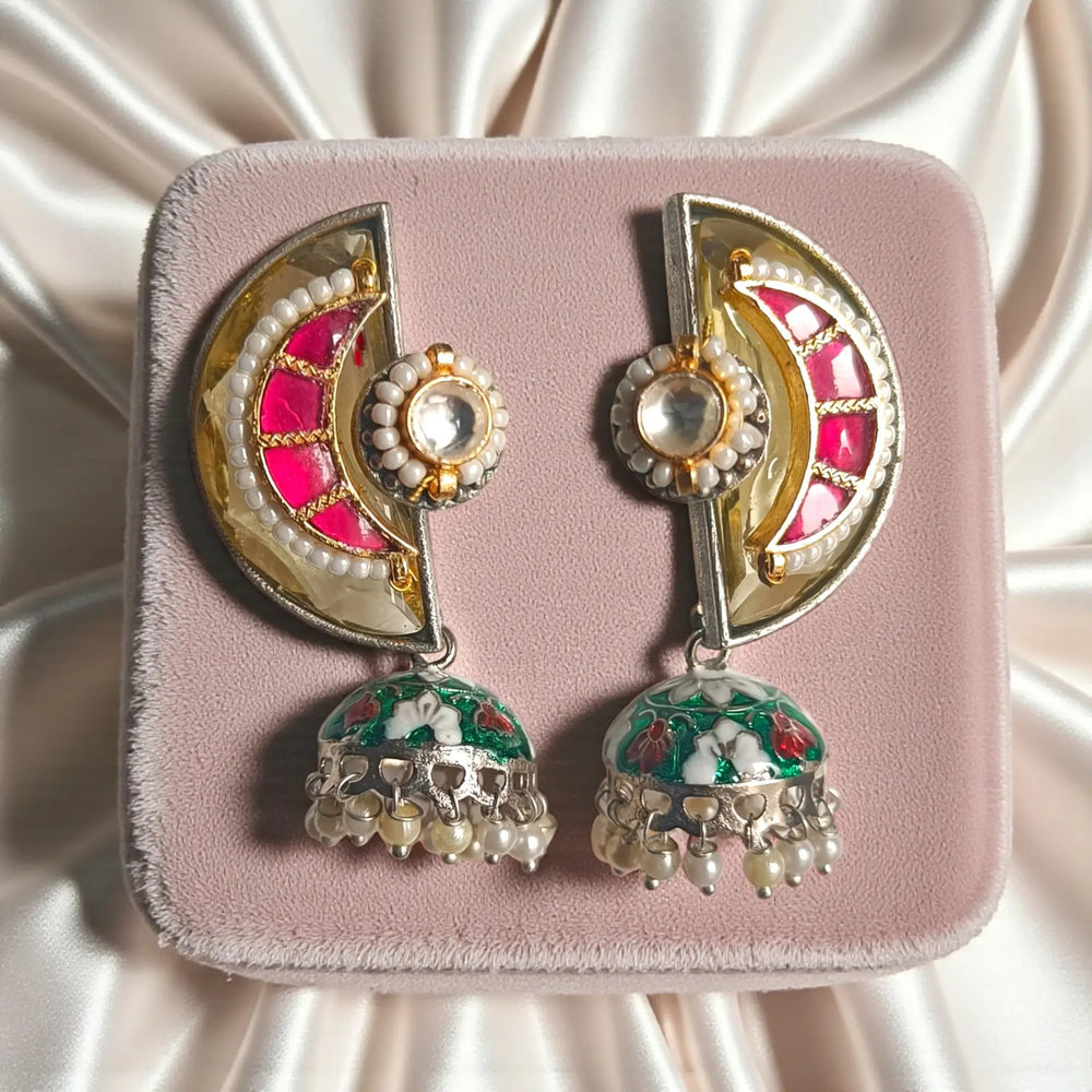 Red tones brighten the dual-tone silver-plated surface of this earring.