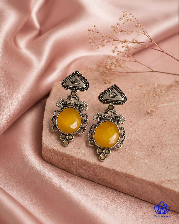 Sleek detailing highlights the yellow tones of this earring.