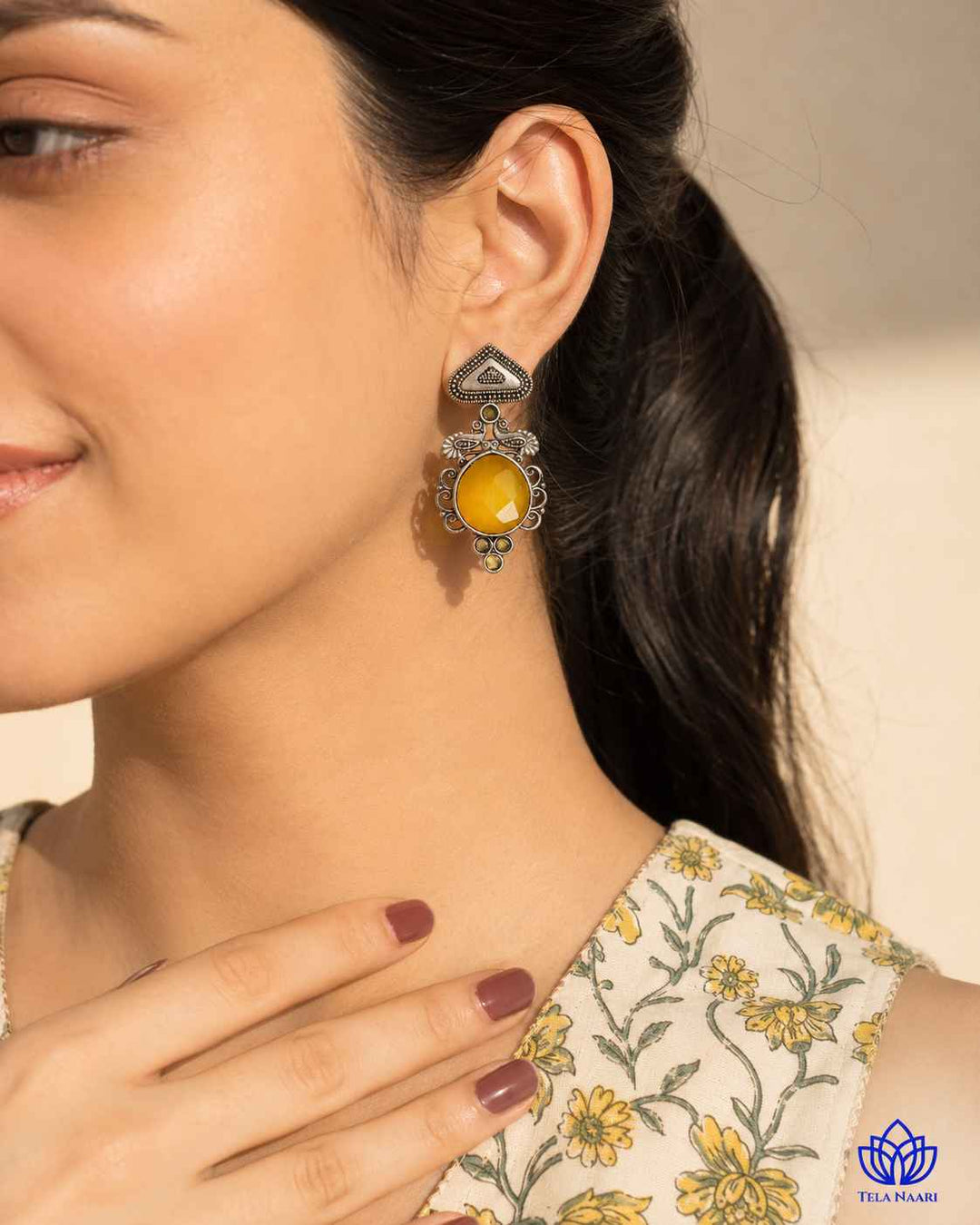 Yellow accents sit against the layered oxidised silver surface.