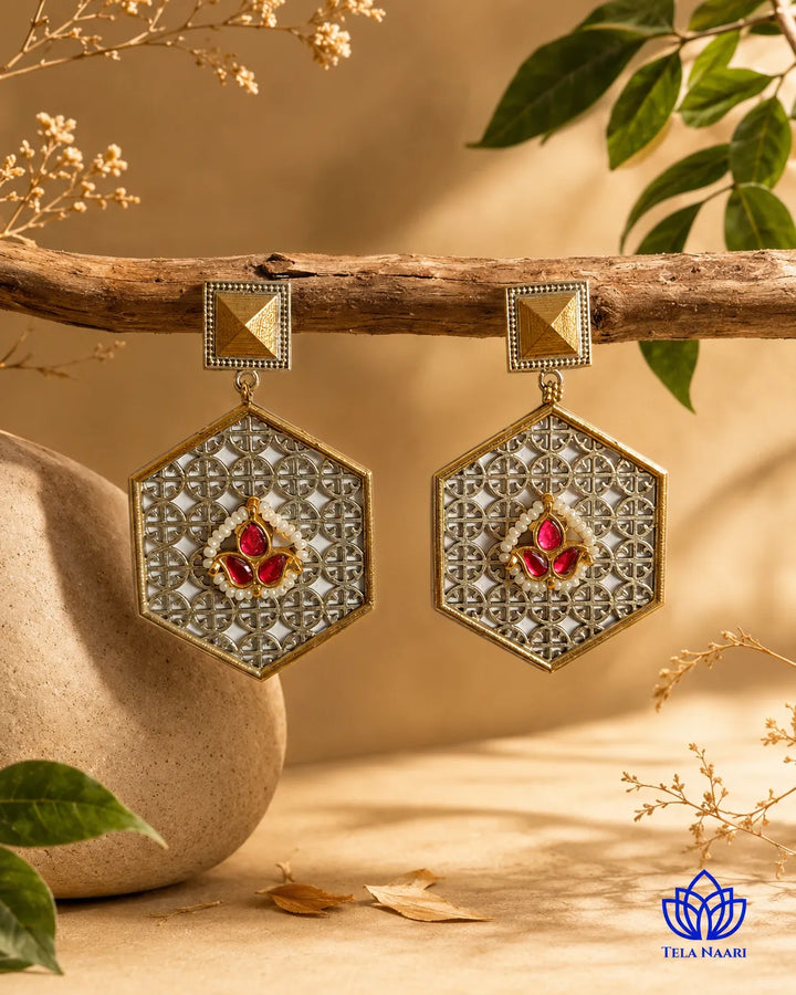 Contemporary silhouette combines hexagon geometry with ruby-red stones.