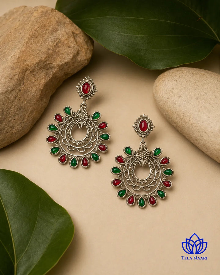 Vibrant red and green gemstones sit at the centre of this earring.
