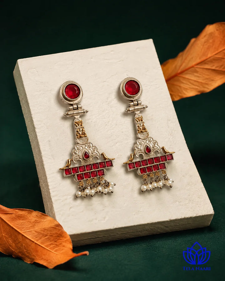 Sophisticated silhouette pairs ruby accents with dual-tone plating.