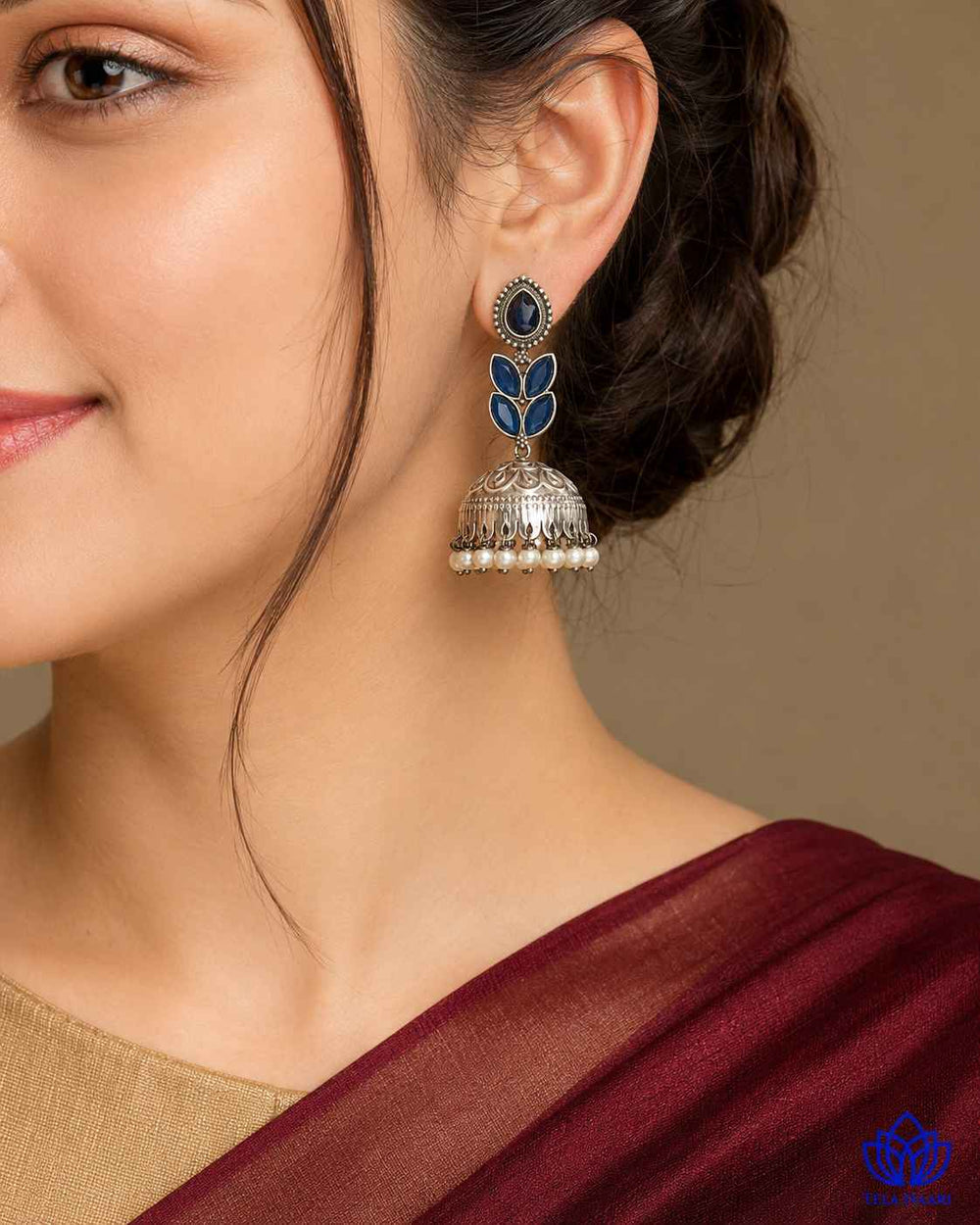 Blue artificial stone detailing sits within the teardrop earring shape.