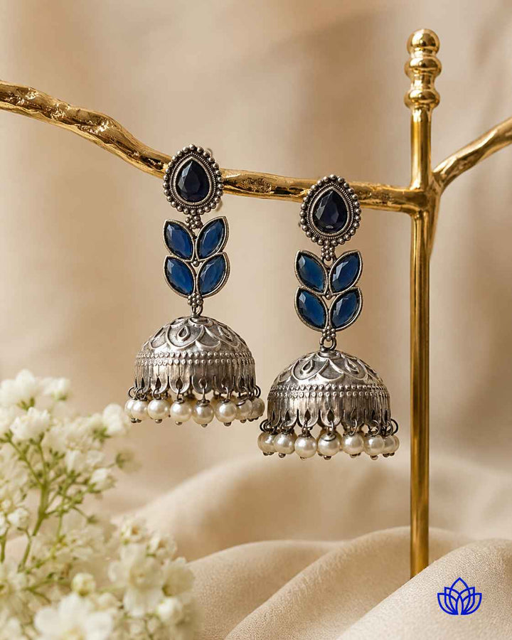 Artificial stone accents highlight the blue tones of this jhumka.
