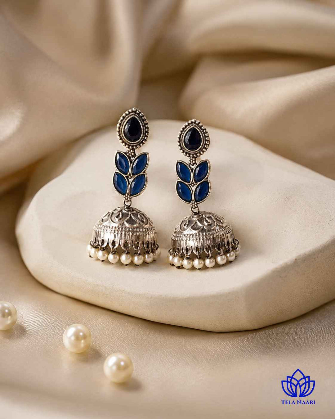 Polished surface reflects light across this blue teardrop earring.