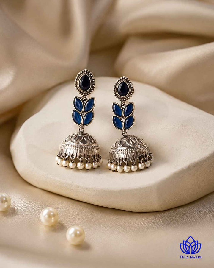 Polished surface reflects light across this blue teardrop earring.