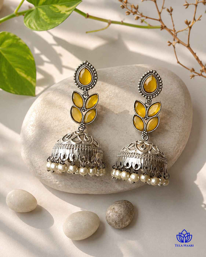Golden-yellow tones brighten the silver-plated surface of this earring.