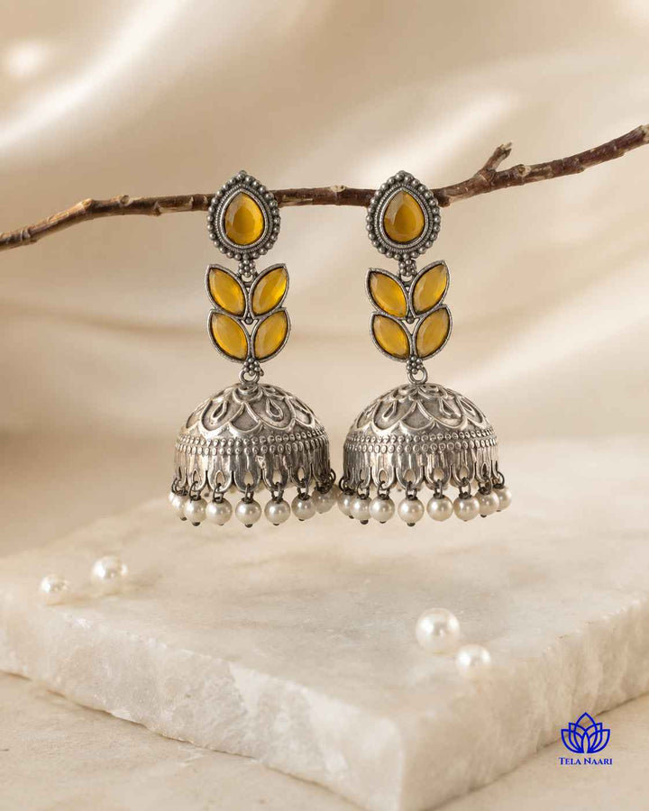Push-back stopper closure secures this silver-plated jhumka earring in place.