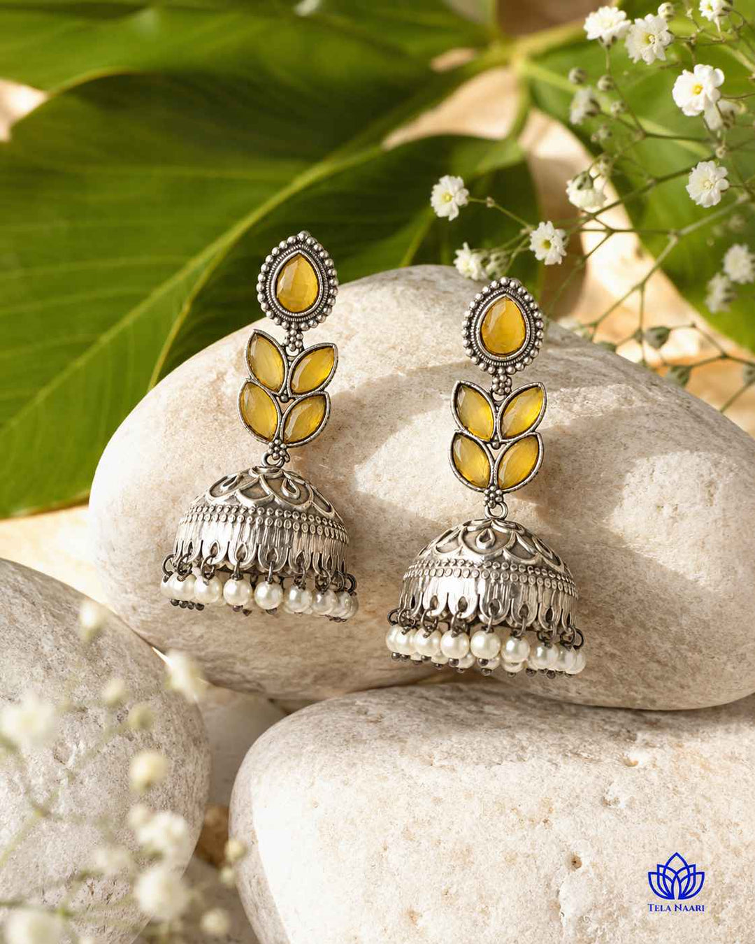Teardrop-shaped earring features a silver-plated finish with yellow stone accents.
