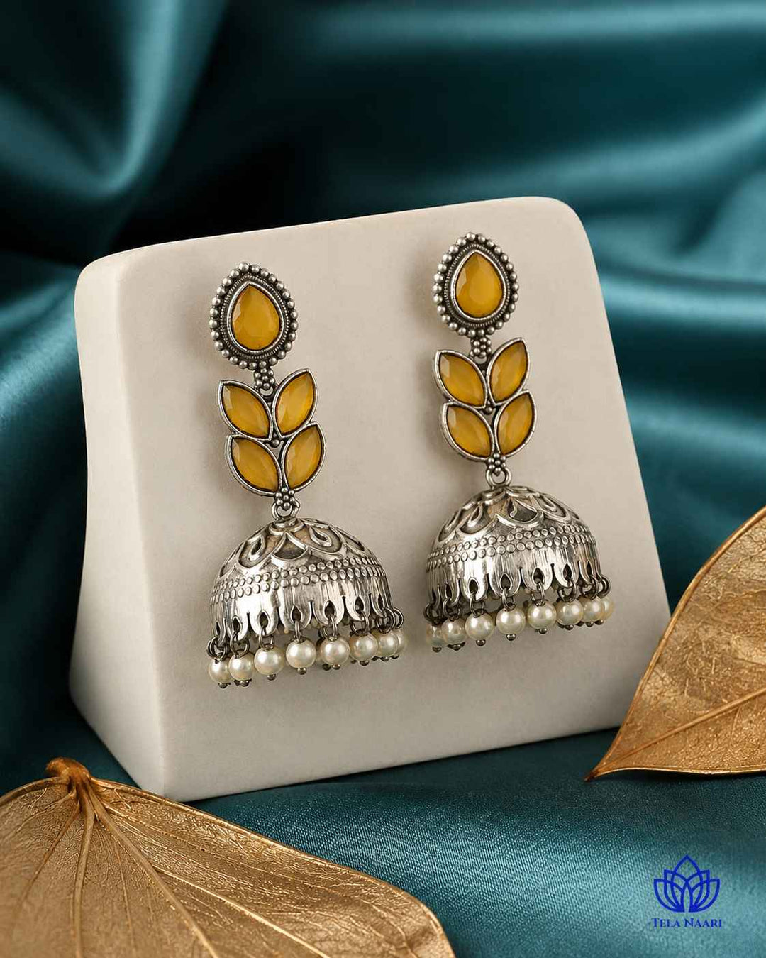 Yellow stone detailing sits at the centre of this jhumka earring.