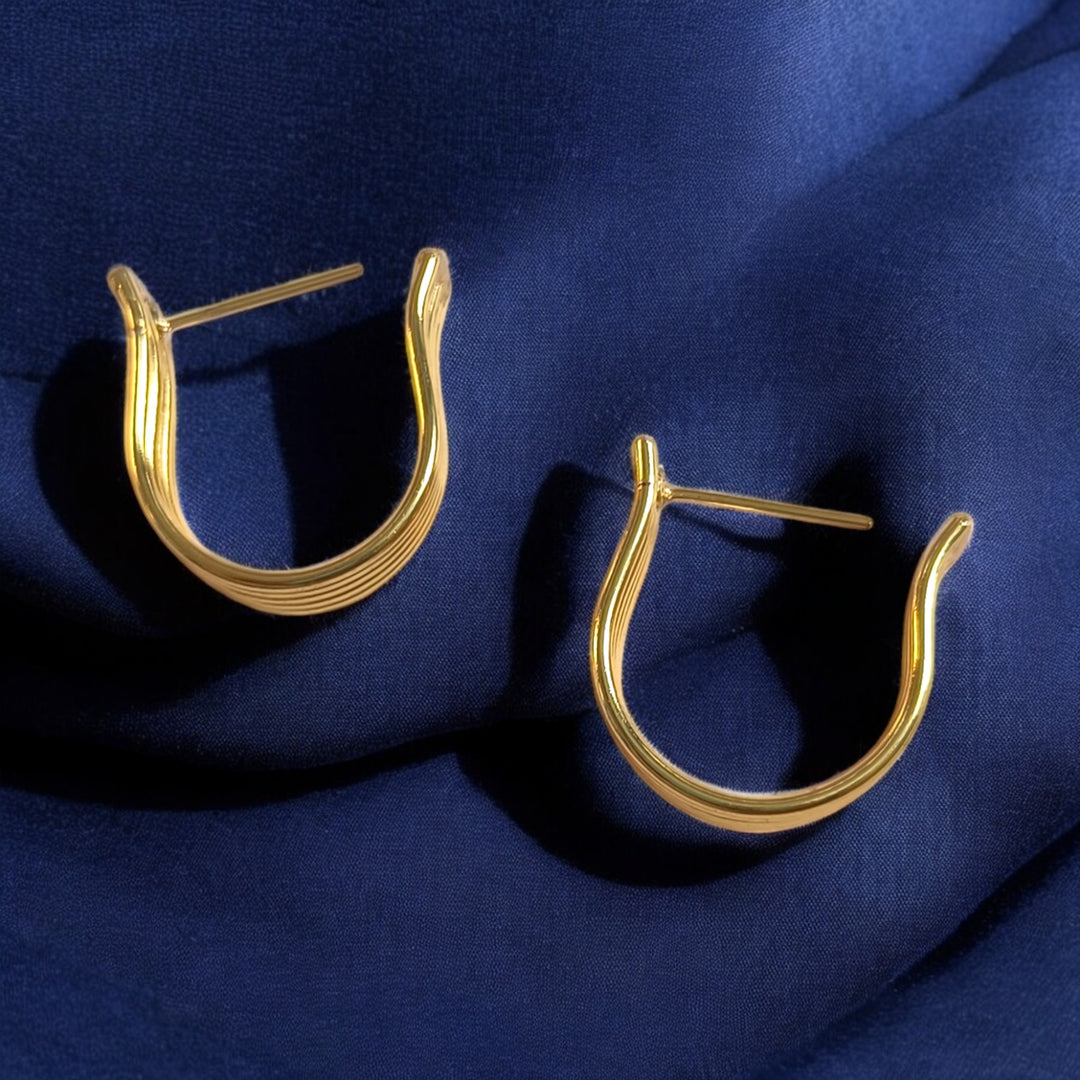 Classic hoop silhouette defines the shape of this gold-plated earring.