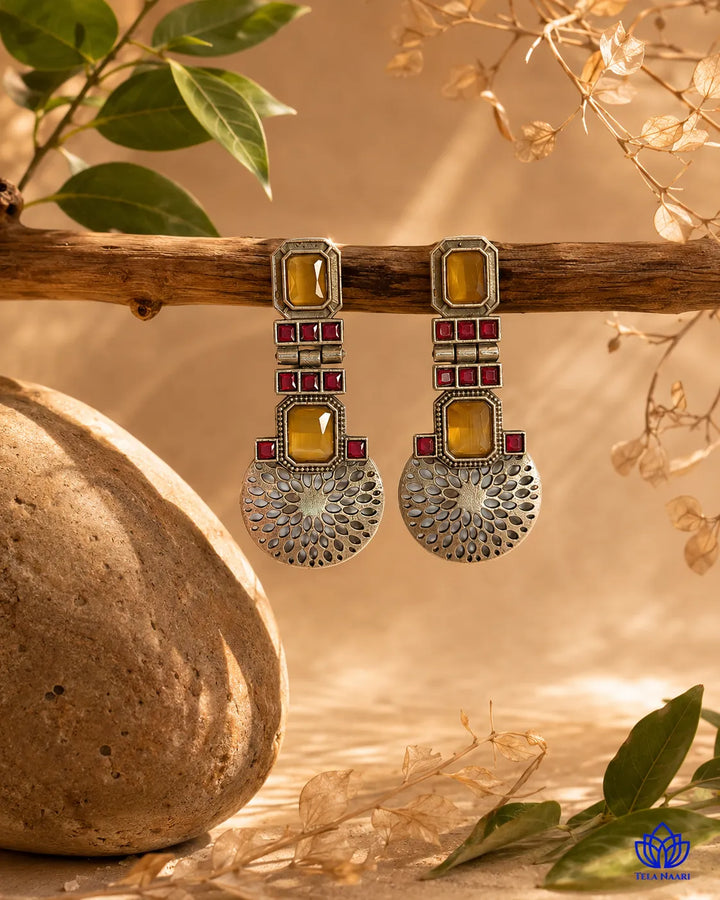 Bold contrast defines the amber and ruby tones of this earring.